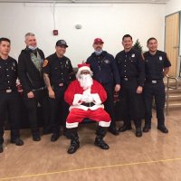 12-10-21 - Mission Education Center Christmas with Santa @ MEC, San Francisco - Members of Los Bomberos Firefighters, including Santa, and Steve Martin (second from left).