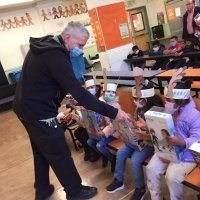 12-10-21 - Mission Education Center Christmas with Santa @ MEC, San Francisco - Steve Martin hands out S. F. Sheriff’s stickers out to a row of students.