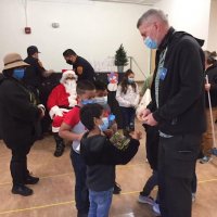 12-10-21 - Mission Education Center Christmas with Santa @ MEC, San Francisco - Steve Martin hands out S. F. Sheriff’s stickers to students.