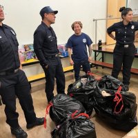 12-9-22 - Mission Education Center Christmas with Santa, San Francisco - Members of Los Bomberos, with a little help, hae brought in presents for the children.