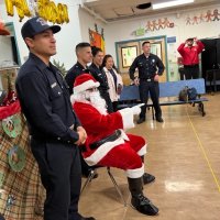 12-9-22 - Mission Education Center Christmas with Santa, San Francisco - Members of Los Bomberos, and others, take time to pose with Santa.