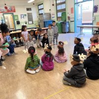 12-9-22 - Mission Education Center Christmas with Santa, San Francisco - Students sing with their teacher for Santa as she plays her ukulele.