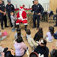 12-9-22 - Mission Education Center Christmas with Santa, San Francisco - A student happily accepts his present from Santa.