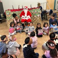 12-9-22 - Mission Education Center Christmas with Santa, San Francisco - A few members of a class pose with Santa after getting their gifts.