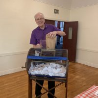 4-20-22 - Italian American Social Club, San Francisco - The last bag of stubs being emptied into the drum by chairman Lyle Workman before the start of the drawing meeting.