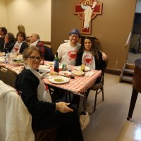 2-25-23 - 36th Annual Crab Feed - St. Philip the Apostle Church, San Francisco - Guests enjoying; at end of the table, far side: Joe & Francisca Workman; near side: Linda Workman.
