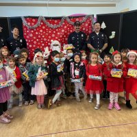12-13-23 - 42nd Annual Christmas with Santa @ Mission Education Center, San Francisco - The class happily poses with Santa and shows off their presents just received.